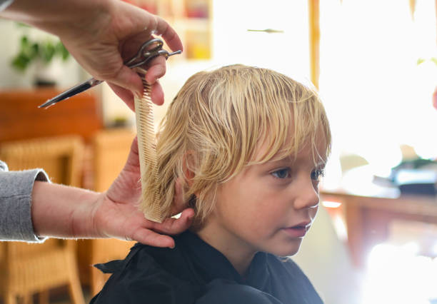 A boy getting a haircut at home stock photo