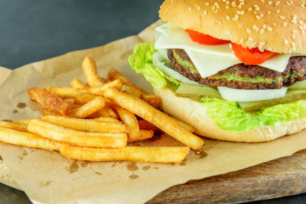 istock Burger vegetarian with spinach cutlet, ingredients and fried potato on the wooden cutting board closeup. Tasty light fast food. Enjoying tasty food. 1237467855