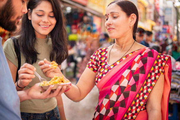 시장에서 길거리 음식 (bhelpuri)을 즐기는 행복한 인도 가족. - india indian culture women market 뉴스 사진 이미지