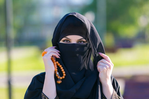 istock Muslim woman stands with prayer beads Islamic scores. 1237467991