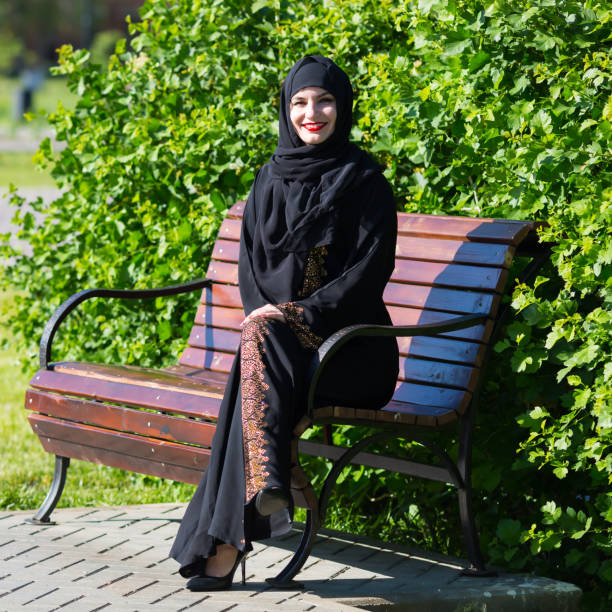 istock A beautiful young muslim woman is sitting on a bench. 1237468013