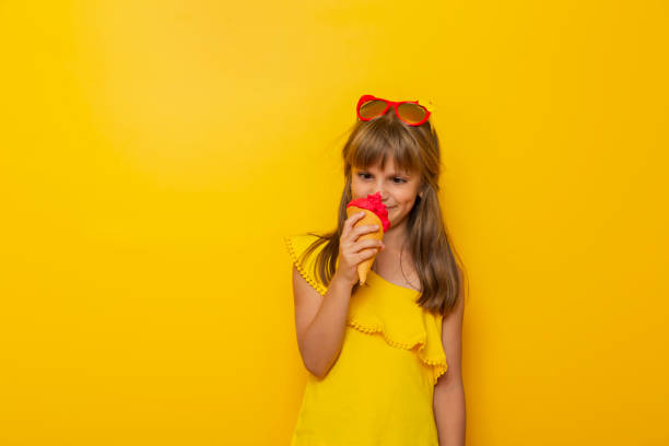 istock Little girl making funny faces while eating an ice cream 1237480967