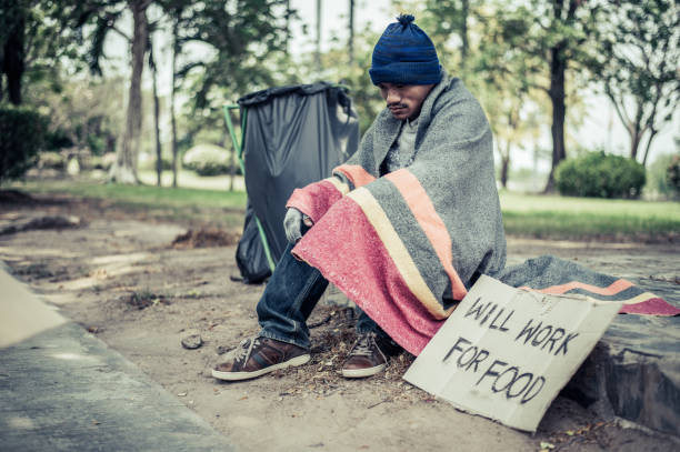 istock Beggars, wrapped in cloth, then wearing a hat and sitting down beside the road. 1237489952