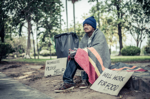 istock Beggars, wrapped in cloth, then wearing a hat and sitting down beside the road. 1237490463