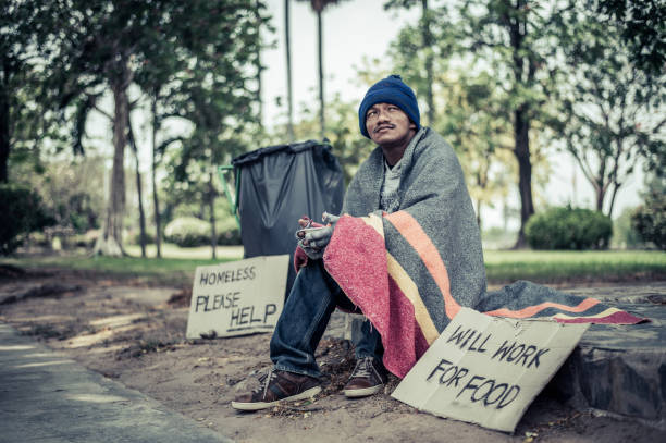 istock Beggars, wrapped in cloth, then wearing a hat and sitting down beside the road. 1237490480