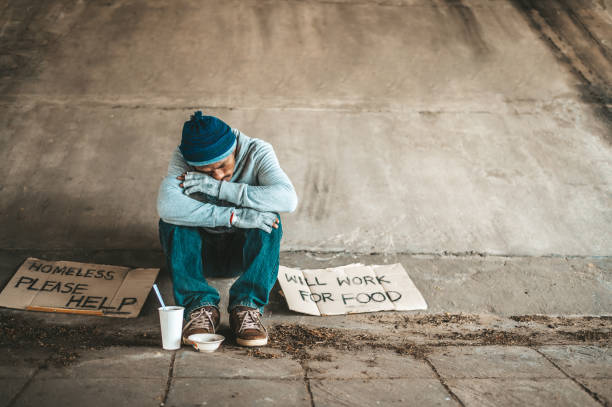 istock Beggars sitting under a bridge with cups have money. 1237536988