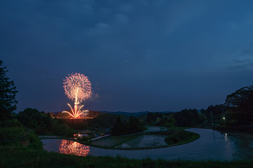 Fireworks reflecting in terraced rice fields in Japan