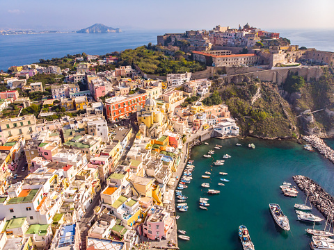 Aerial drone view of vibrantly colorful houses of Marina Corricella in sunny summer weather at Procida island, Italy