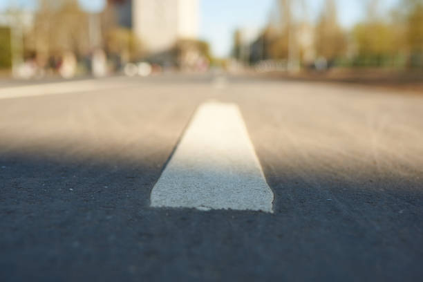 istock White line perspective. Road marking on street background in blur. 1237594654