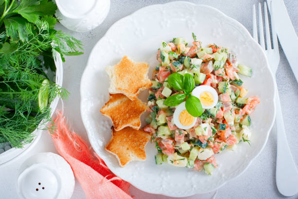 istock Salad with red fish, fresh cucumbers and herbs, egg with white bread toast, selective focus, top view 1237600944