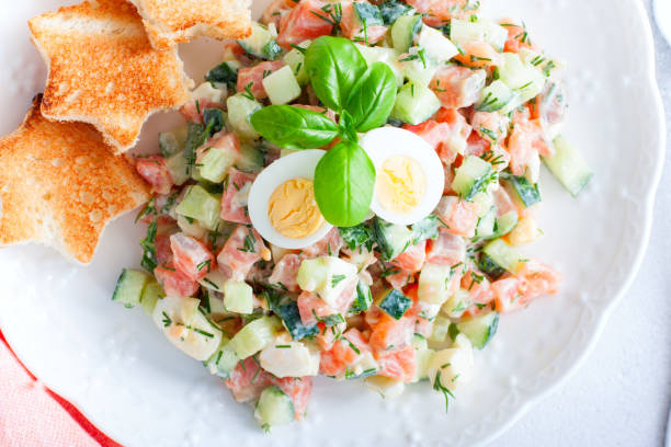 istock Salad with red fish, fresh cucumbers and herbs, egg with white bread toast, selective focus, top view 1237600946