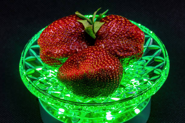 Strawberries in a crystal bowl on a black background with lighting