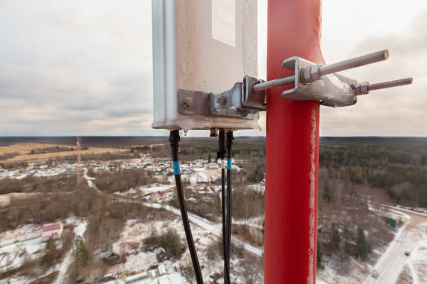istock Top of red telecommunication tower with vertical panel antenna  and  remote radio unit, power and optic cables in winter day 1237659934