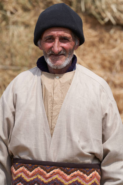 istock Old farmer man with Hay bales on background. Elderly muslim farmer 1237662974
