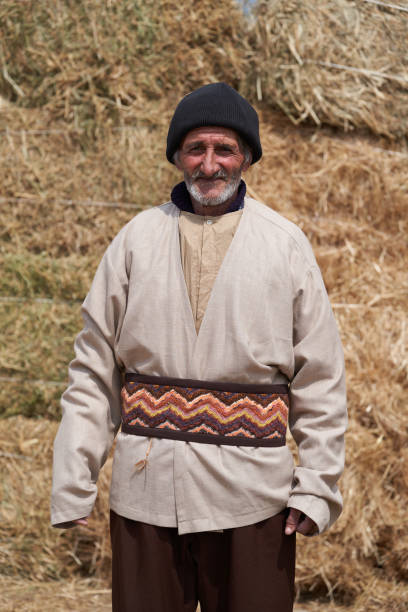 istock Old farmer man with Hay bales on background. Elderly muslim farmer 1237663061