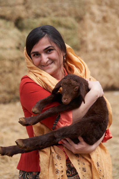 istock Young farmer woman with her lamb at the farm 1237663092