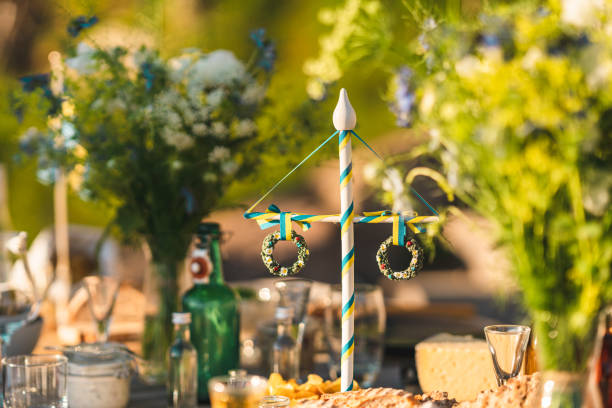 Maypole on Midsummer Dinner Table A traditional Swedish maypole decoration on the table at midsummer. Surrounded by food and flowers. summer solstice stock pictures, royalty-free photos & images