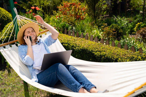istock woman lies in hammock, answers phone call 1237700784