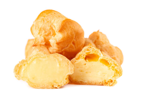 Homemade profiteroles with cream,isolated on a white background. Fresh baked golden profiterole. Custard cake. Homemade profiteroles with cream,isolated on a white background. Fresh baked golden profiterole. Custard cake choux pastry photos stock pictures, royalty-free photos & images