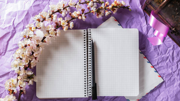 istock Open blank notebook, pen and cherry blossoming branch on bright background. Writing letters, correspondence concept 1237704604