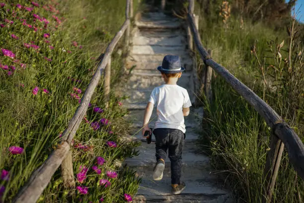 Photo of Cute little kid running with toy upstairs