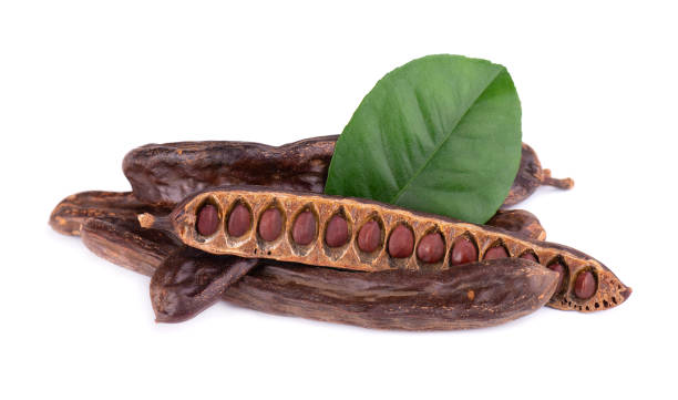 reife karob hülsen und b'an isoliert auf weißem hintergrund. - carob bean stock-fotos und bilder