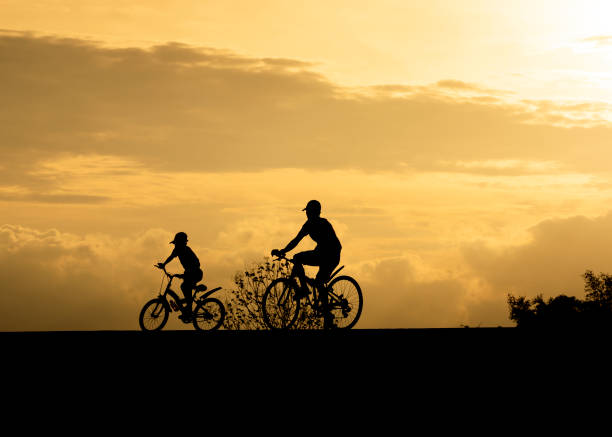 istock silhouette elder and brother riding 1237725989