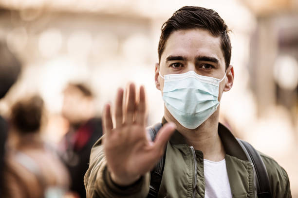 istock Serious Man doing stop sign with mask on street 1237731863