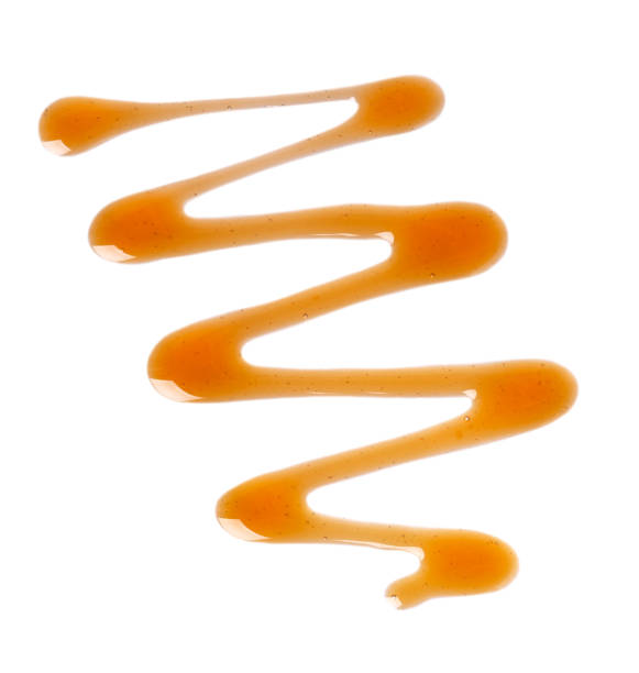 istock Caramel syrup drizzle isolated on white background. Splashes of sweet caramel sauce. Top view. 1237736073