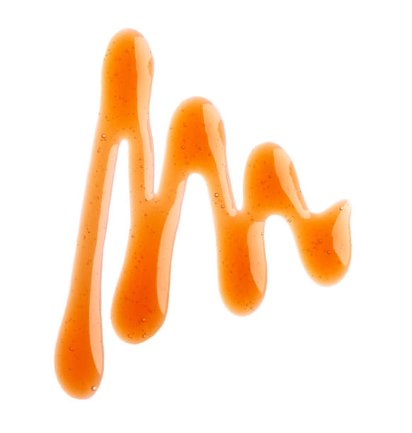 istock Caramel syrup drizzle isolated on white background. Splashes of sweet caramel sauce. Top view. 1237736080