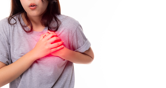 Woman clutch chest from acute pain of heart attack symptom. Severe heart ache, young woman suffering from chest pain, having heart attack or painful cramps, pressing on chest, coronary artery disease