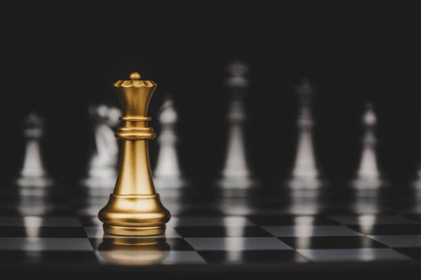 istock Leadership. gold queen with silver chess pieces on chess board game competition on dark background, chess battle, victory, success, management, team leader, teamwork and business strategy concept 1237785395