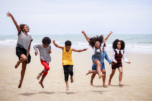Funny vacation. Children or kids playing and romp together at the beach on holiday. Having fun after unlocking down the city from COVID19. Seven African American kids. Ethnically diverse concept