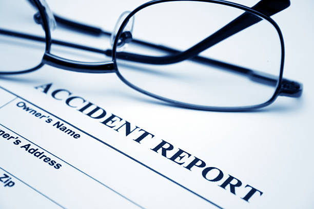 Wire rimmed glasses sitting on a blank accident report  stock photo