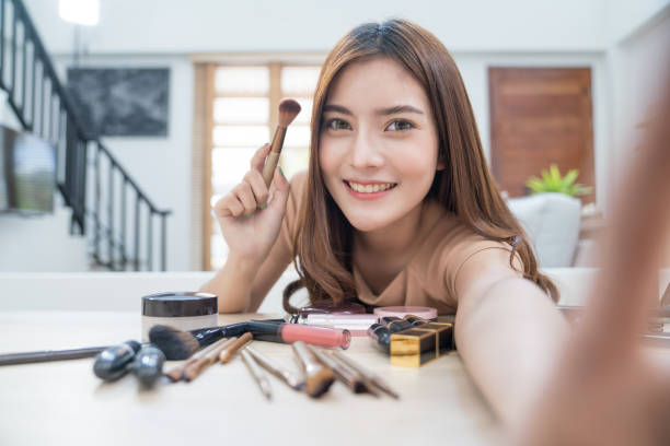 Young beautiful asian woman professional beauty vlogger or blogger recording make up tutorial to share on social media Young beautiful asian woman professional beauty vlogger or blogger recording make up tutorial to share on social media how to sell my photography online stock pictures, royalty-free photos & images