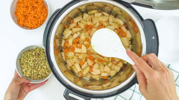 recette multicuise. cuisson des légumes. carotte, pommes de terre, lentilles et certains ingrédients se rapprochent dans une casserole, vue d’en haut - carrot close up silverware cutting board photos et images de collection