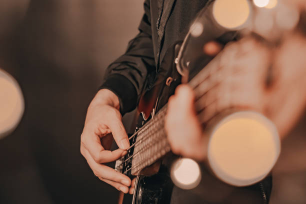 istock Man playing electric bass guitar blurred background with beautiful bokeh. 1237883633
