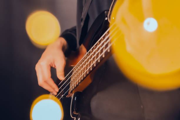 istock Man playing electric bass guitar blurred background with beautiful bokeh. 1237883642