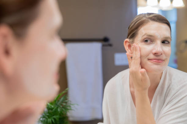 istock Woman smiles while washing face in bathroom 1237894693