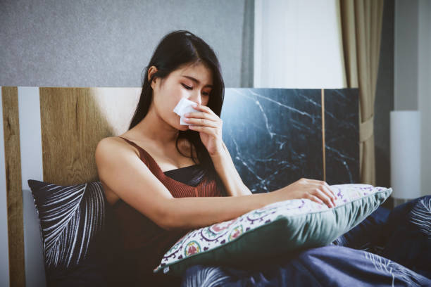 istock Sick woman covered with a blanket lying in bed with high fever and a flu 1237922041