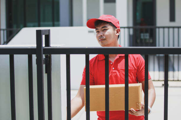 istock red delivery Man Holding Cardboard Box Ringing The Door Bell 1237932595