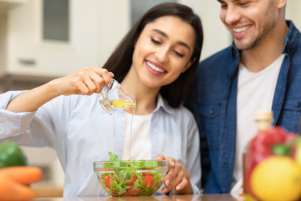 istock Happy young couple preparing salad together at home 1237953295