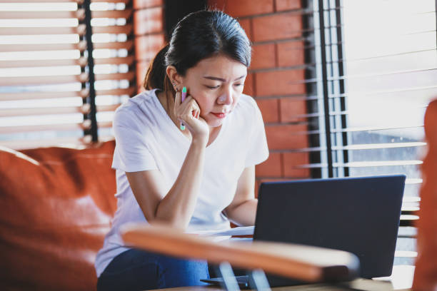 istock new normal life asian woman working at home.woman working on laptop computer while sitting at the living room 1237954381