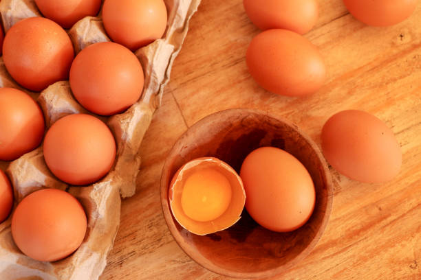 istock Cracked egg in bowl and egg shells on wooden table 1237966573