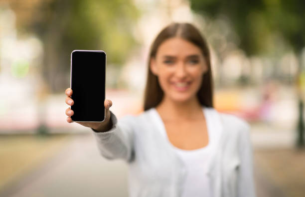 istock Girl Showing Smartphone Empty Screen To Camera Standing Outdoor 1237976674