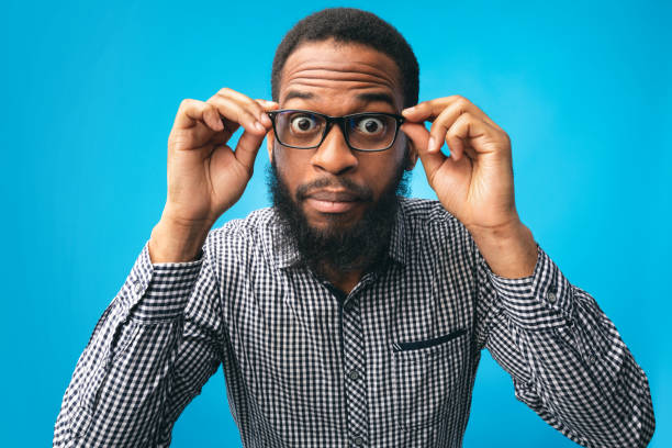 Surprised african american guy touching his eyewear