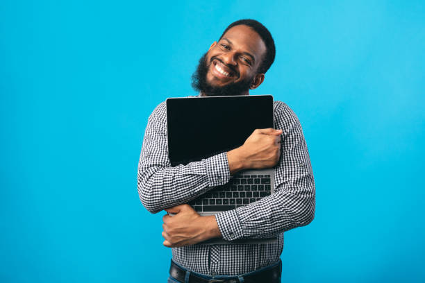 sorrindo homem afro-americano segurando computador pessoal - computer programmer laptop men nerd - fotografias e filmes do acervo