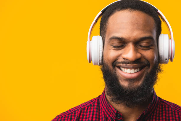 istock Smiling afro guy enjoying music using headphones 1237980966