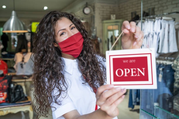 istock Happy business owner hanging an open sign during COVID-19 1237982069