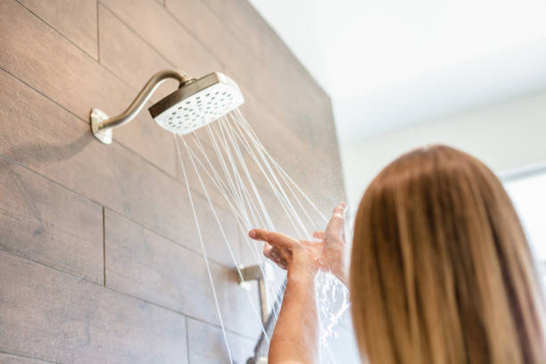 Natural Beautiful Millennial Female Checking Shower Water Temperature stock photo